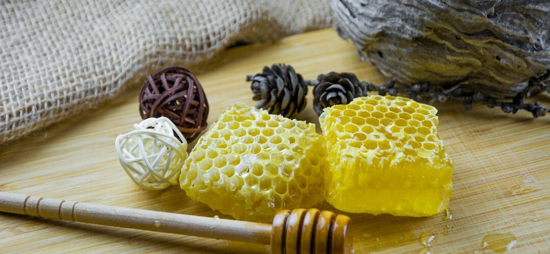 Honigglas mit Honiglöffel auf einem Holztisch
