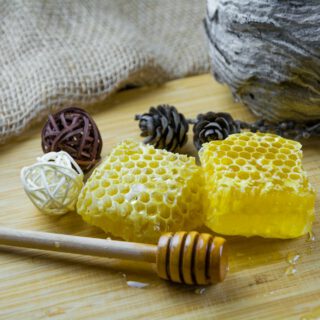 Honigglas mit Honiglöffel auf einem Holztisch