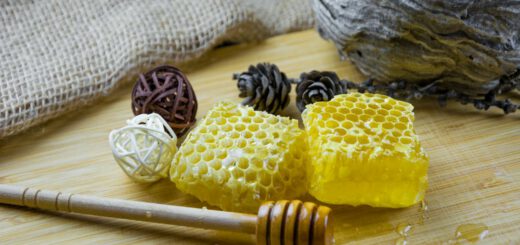 Honigglas mit Honiglöffel auf einem Holztisch